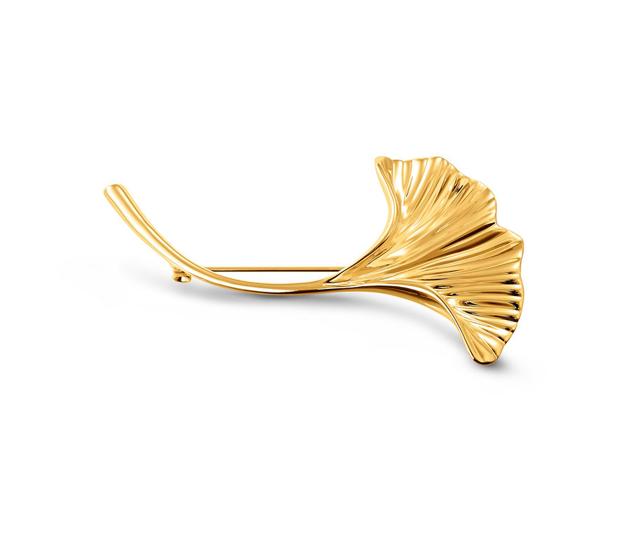 Eine goldene Brosche »Ginkgoblatt« liegt auf einem weißen Hintergrund.