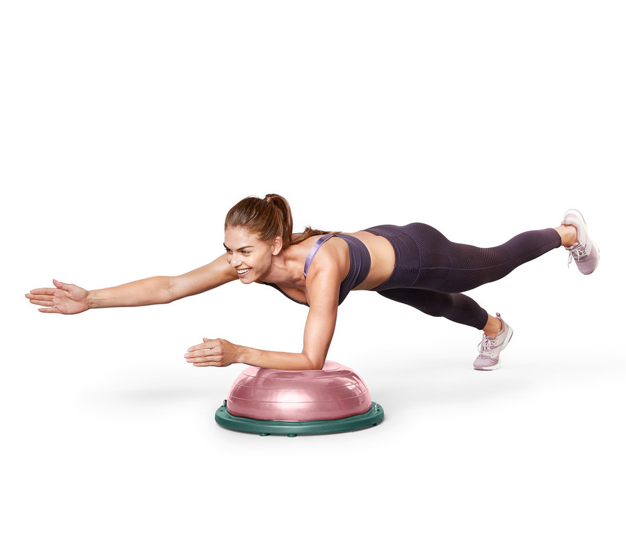 Frau macht Plank auf einem Balance-Ball.