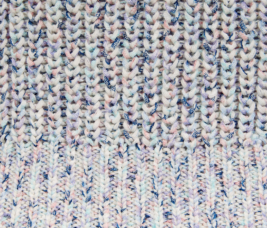 Detailaufnahme eines Strickpullovers aus Bändchengarn mit farbigen Akzenten.
