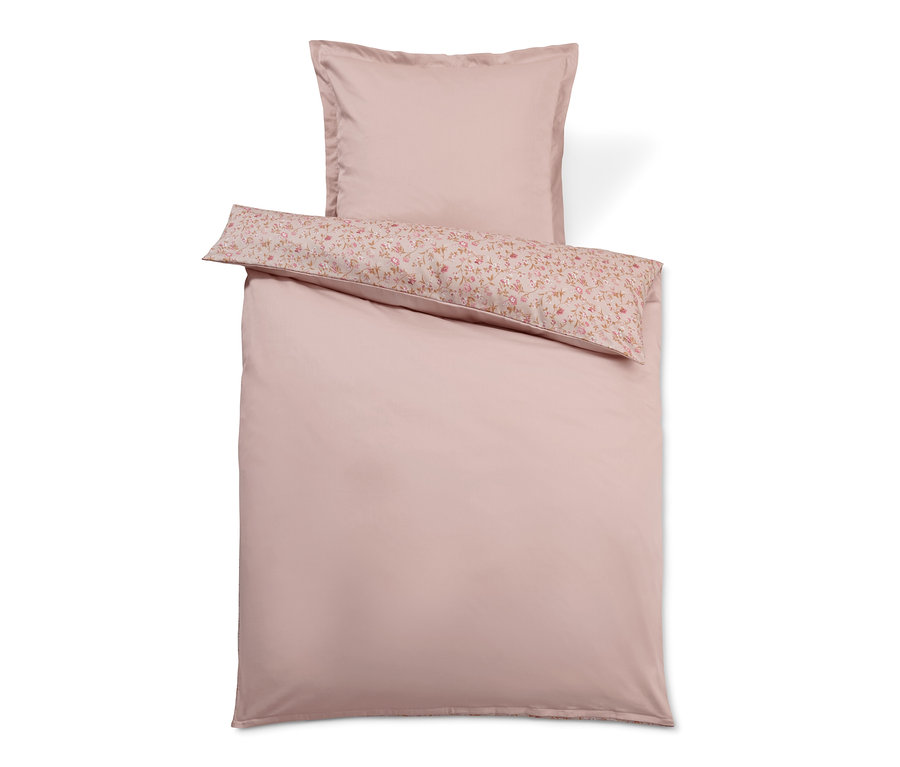 Rosa Satin-Bettwäsche mit Blumenkissen.