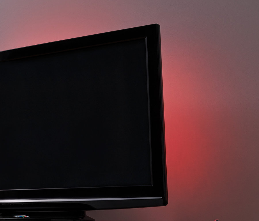 Schwarzer Fernseher mit LED-TV-Hintergrundbeleuchtung auf einem weißen Tisch.