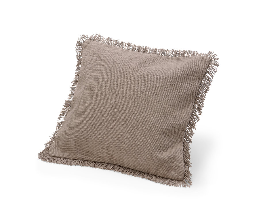 Ein beiger Dekokissen-Bezug mit Fransen liegt auf einem weißen Hintergrund.