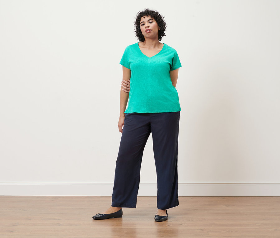 Frau trägt ein Shirt aus Leinenmix in Aqua und eine Webhose in Dunkelblau.