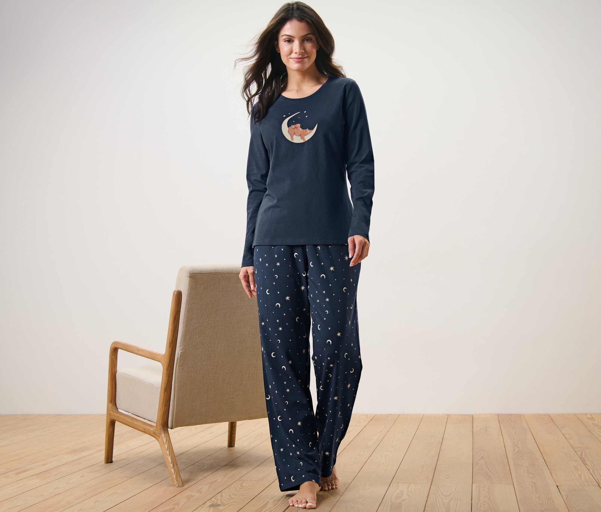 Frau trägt einen dunkelblauen Pyjama mit Bären- und Monddruck.