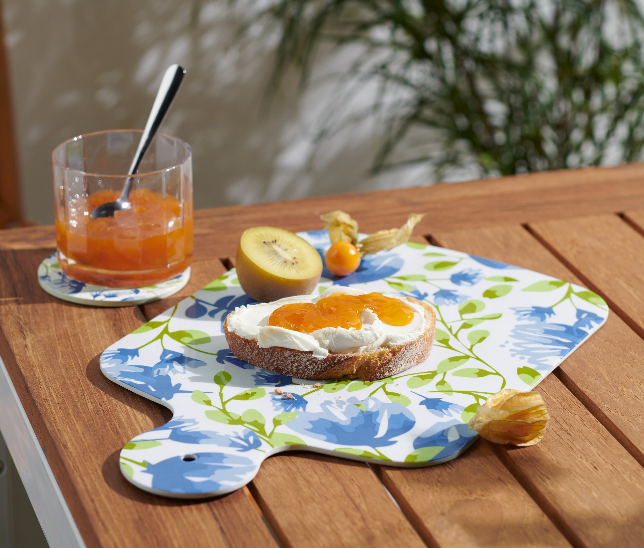 Ein Glas Marmelade und ein Marmeladenbrot auf einem Servierbrett.