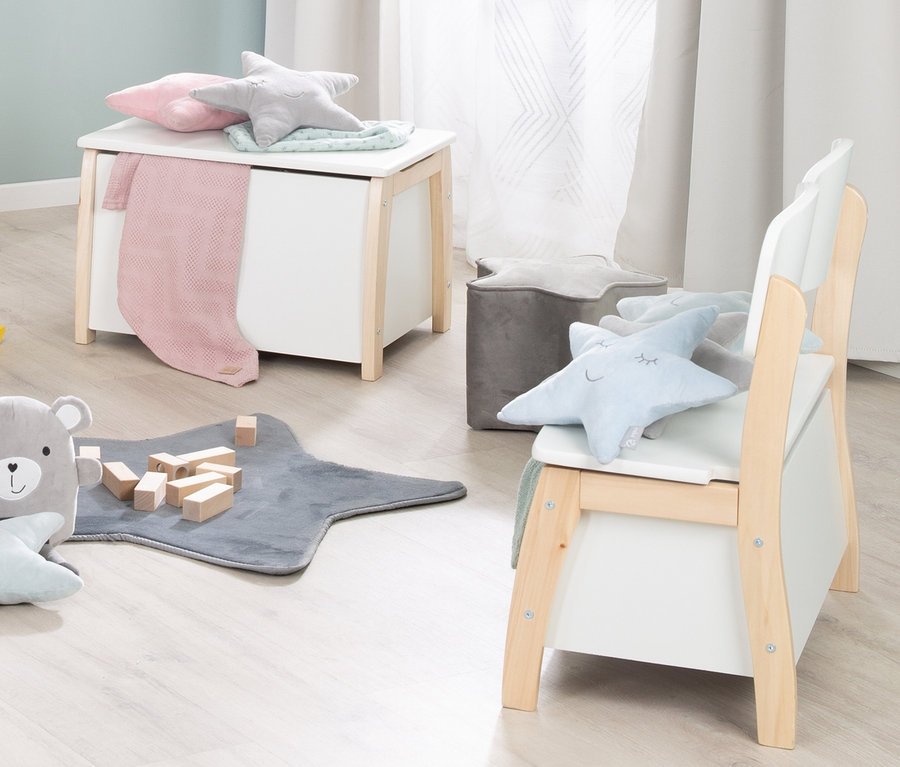 Kinderzimmer mit roba Spielzeugtruhe, Sternkissen und Spielsachen auf dem Boden.