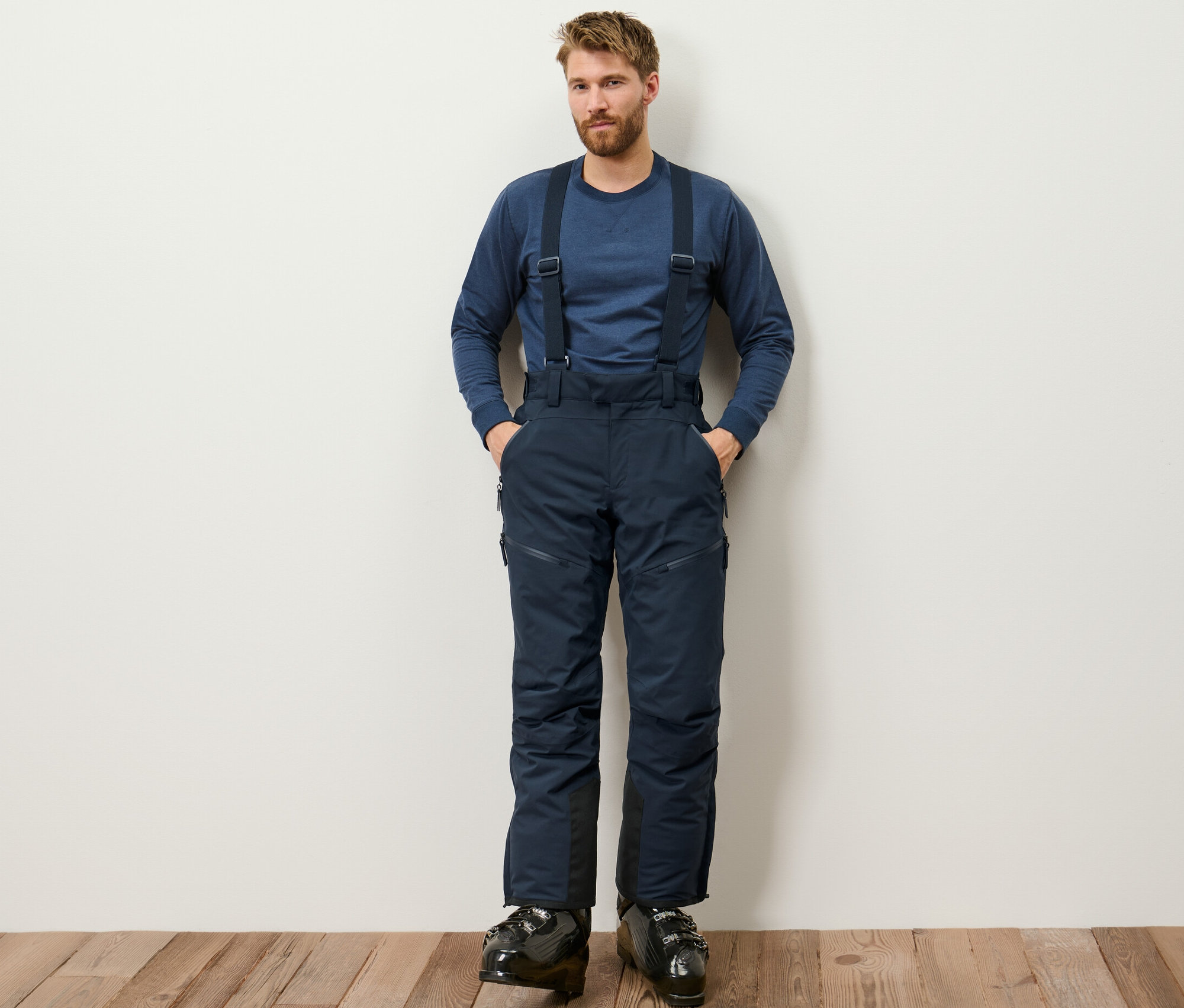 Mann steht und trägt eine blaue High-Tech-Skihose.