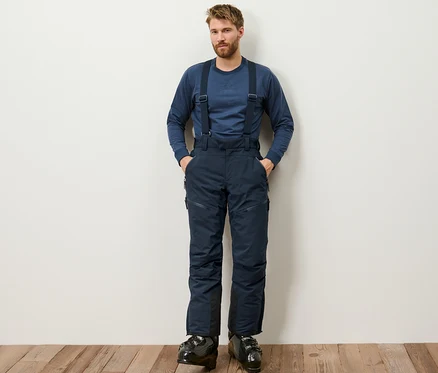 Mann steht und trägt eine blaue High-Tech-Skihose.