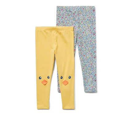 Zwei Kinder-Leggings: eine gelbe mit Küken-Motiv auf den Knien, eine mit Blumenmuster.