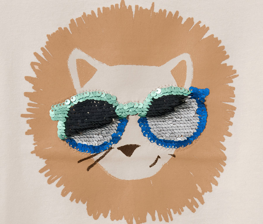 Detailaufnahme eines Kinder-T-Shirts mit Löwengesicht und Wendepailletten auf der Sonnenbrille.
