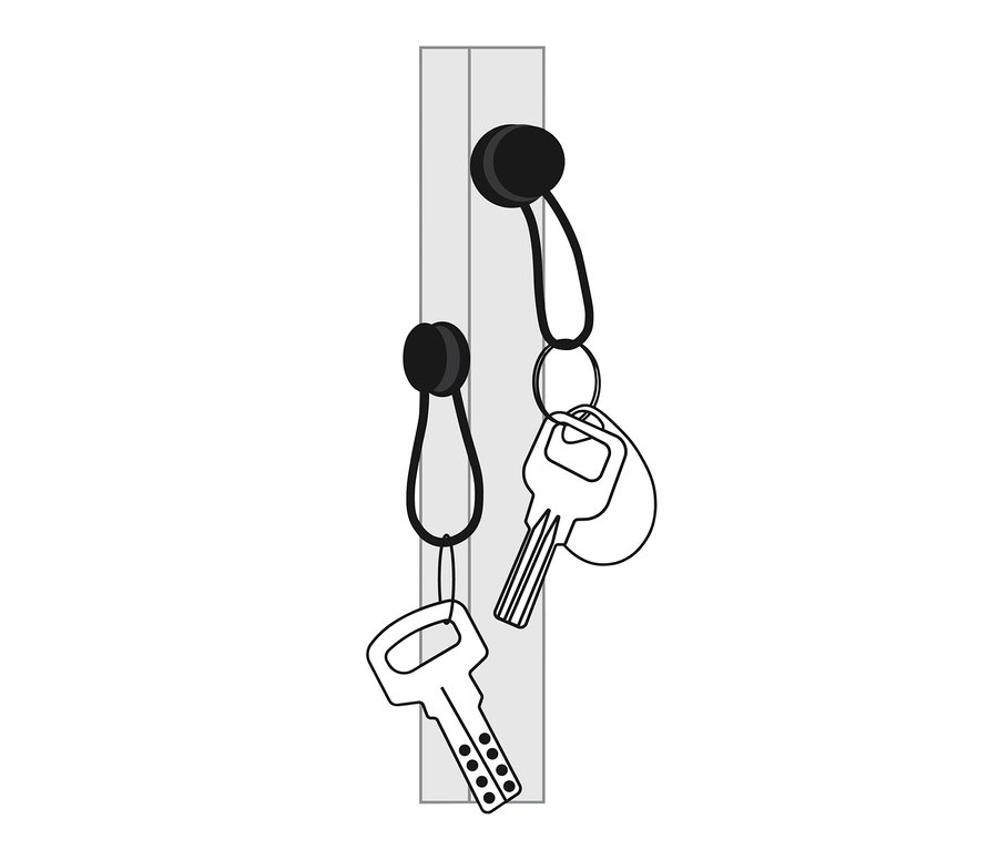 Zwei Magnet-Clips halten zwei Schlüssel auf einer grauen Oberfläche.