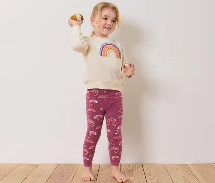 Mädchen wirft Ball, trägt 2 Kinder-Thermoleggings, beere.