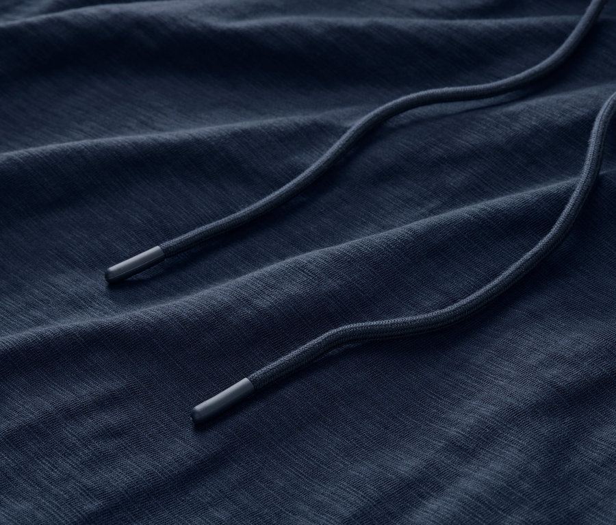 Detailaufnahme des Stoffes eines marineblauen Jersey-Hoodies mit Kordelzug.