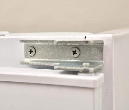 Detailansicht eines weißen Respekta Einbaukühlschranks KS88.4 mit Gefrierfach, Energieeffizienzklasse F, mit einer silbernen Metallhalterung, die mit Schrauben befestigt ist.