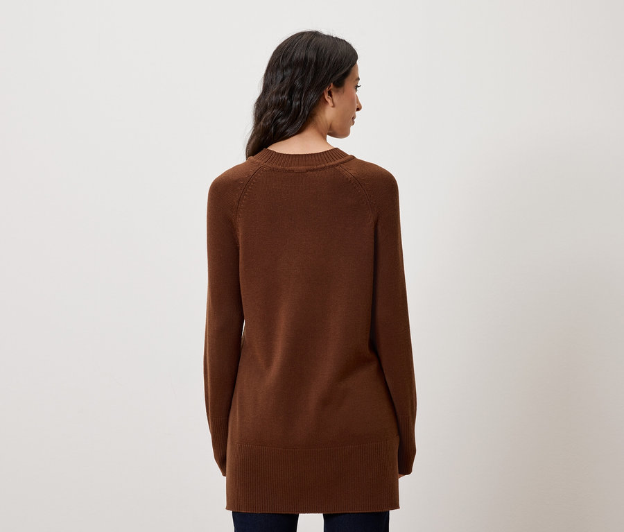 Rückansicht einer Frau mit langen, dunklen Haaren, die einen braunen Langarmpullover trägt.