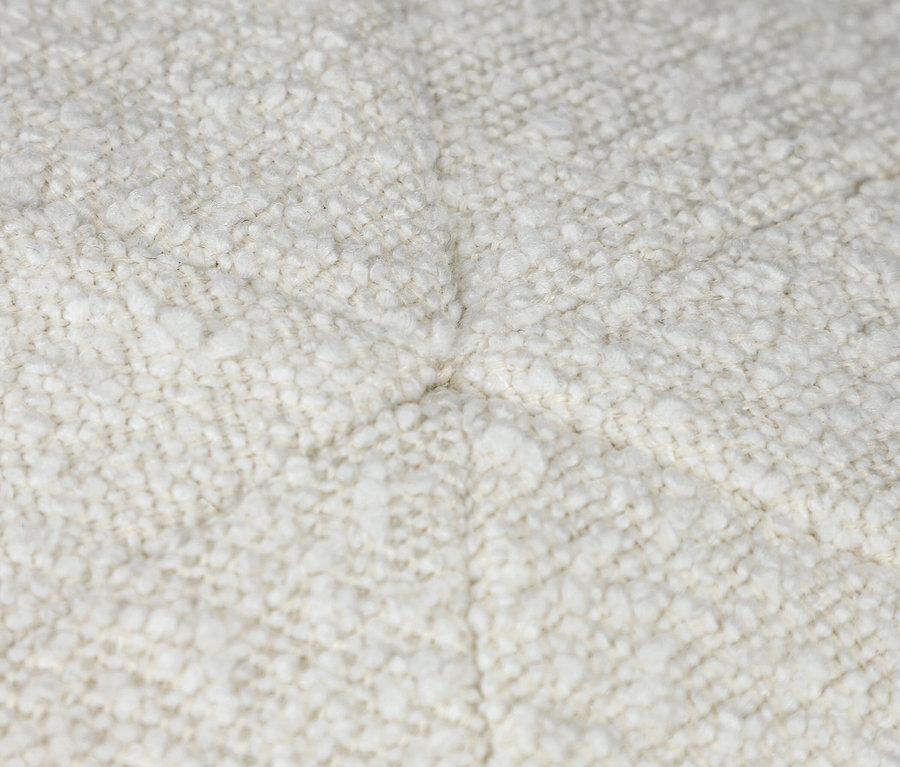 Detailaufnahme eines cremefarbenen Stoffkissens.