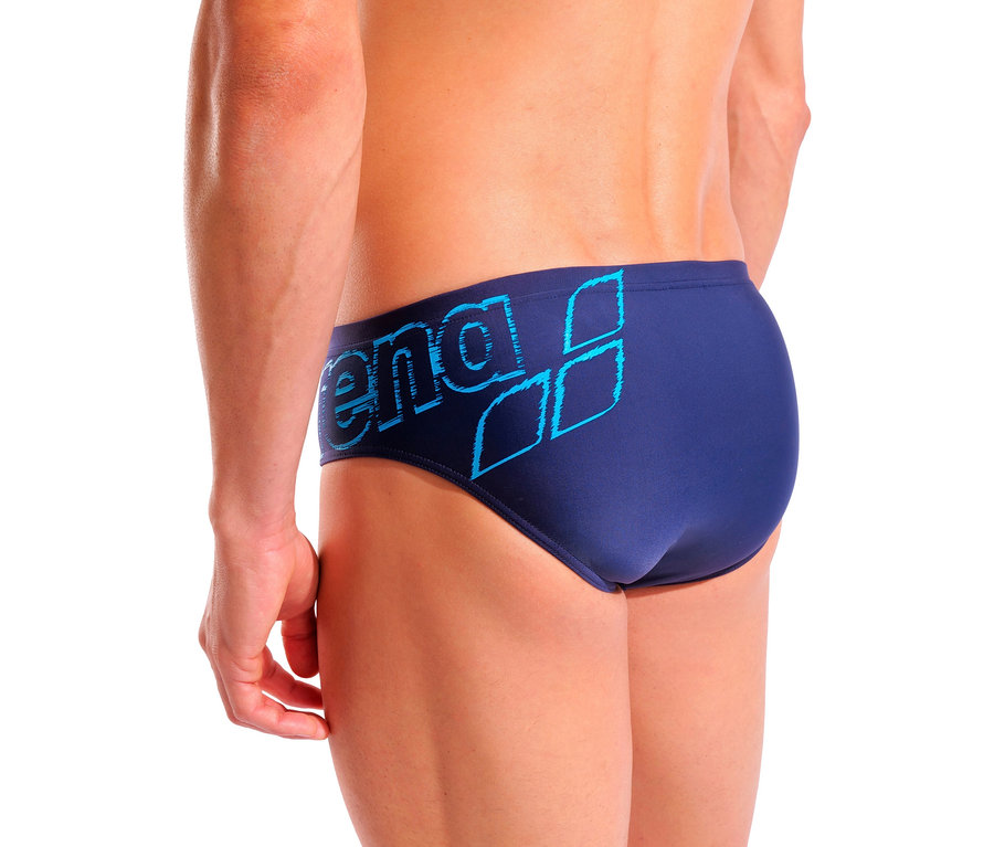 Mann posiert in marineblauen arena Badehosen-Slip Scratchy.