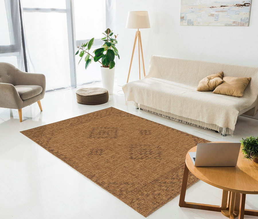 Wohnzimmer mit beigem Sofa, braunem Sessel und braunem Teppich.