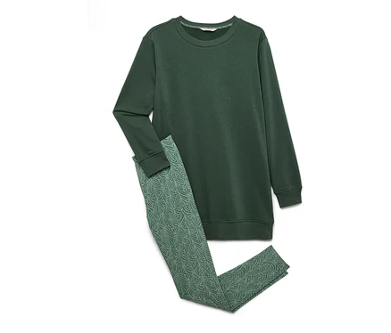 Ein grünes Sweatshirt und gemusterte Leggings liegen auf einem weißen Hintergrund.