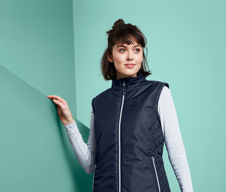 Frau trägt eine marineblaue Reitweste mit recyceltem Material.