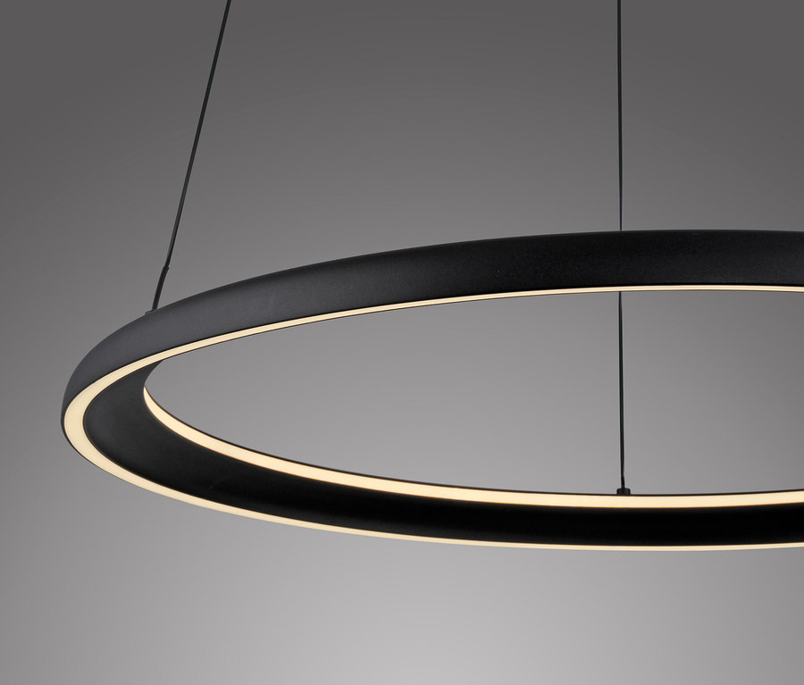 Eine schwarze, kreisförmige LED-Leuchte hängt an dünnen Drähten.