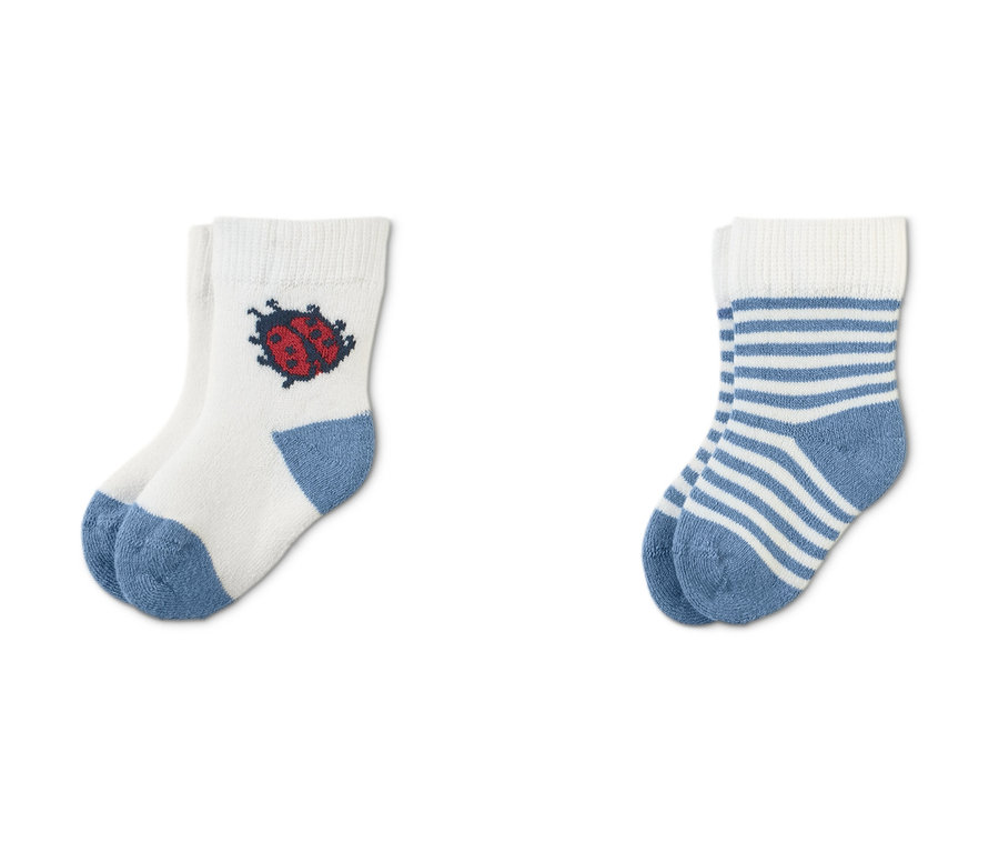 Drei Paar Frottier-Babysocken: weiße mit Marienkäfer, blau-weiß gestreifte und grüne mit Marienkäfer.