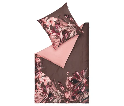 Braune Bettwäsche mit Blumenmuster und rosa Bettlaken.