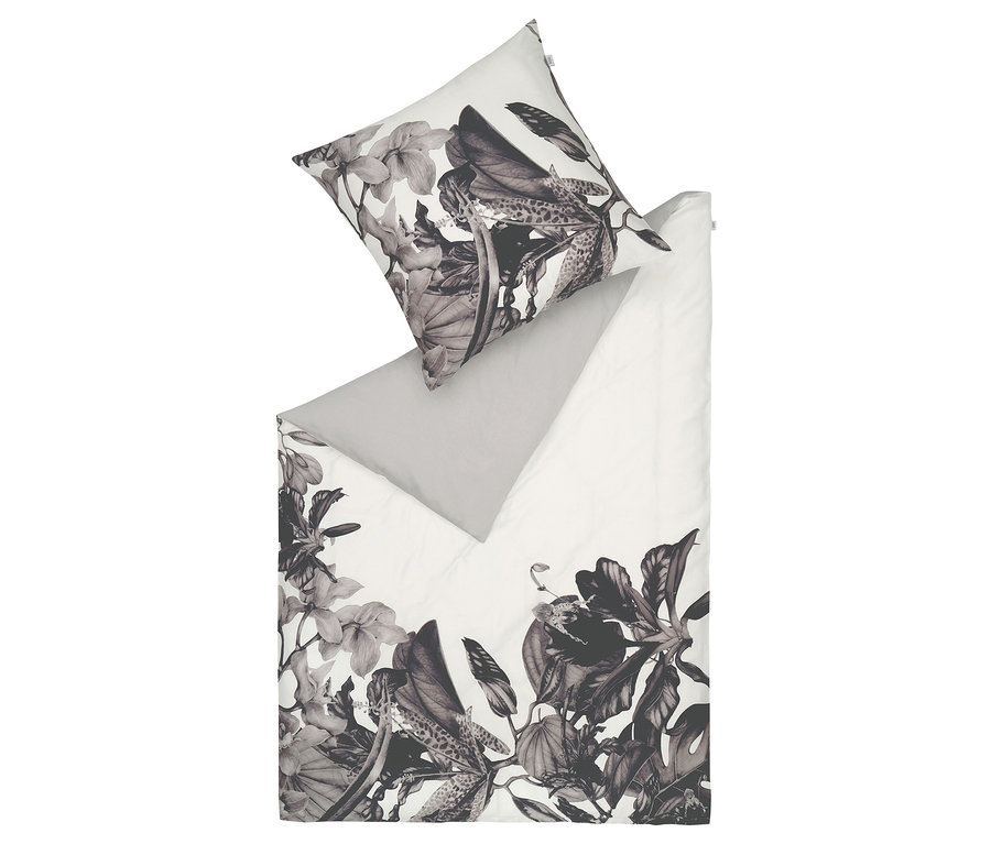 Weiße Bettwäsche mit Blumenmuster und grauem Kissen.