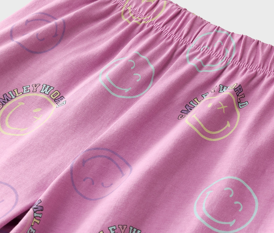 Nahaufnahme einer rosafarbenen Hose mit Gummibund und bunten Smiley-Gesichtern.