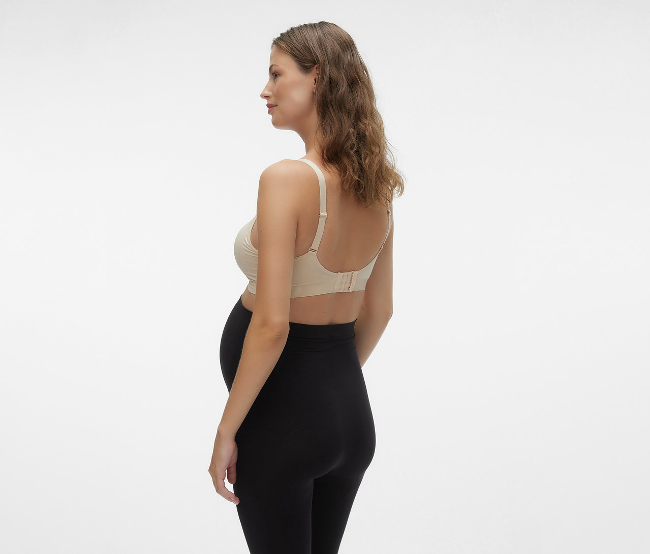 Schwangere von der Seite, mit schwarzer Leggings und MAMALICIOUS MLILJA FEED ME BRA 2-P NOOS Still-BH.