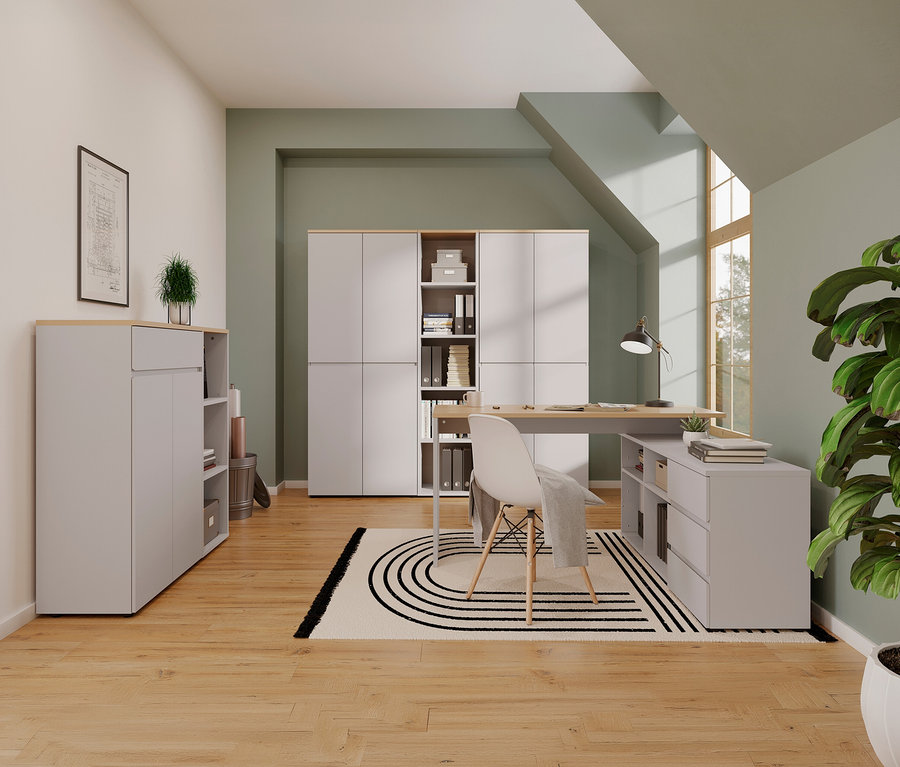Ein Büro mit Winkelschreibtisch »Lissabon«, kleinem Aktenschrank »Lissabon«, Stuhl, Teppich und Zimmerpflanzen.