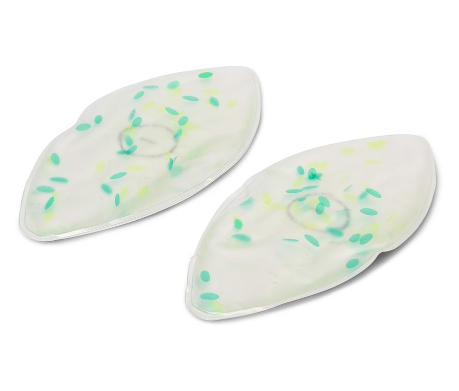 Zwei weiße Gel-Augenmasken mit grünen und gelben Punkten liegen auf einem weißen Hintergrund.