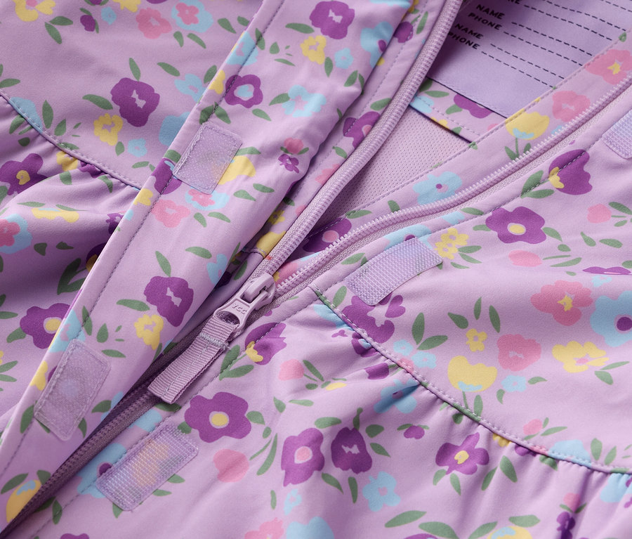 Nahaufnahme einer lila Jacke mit Blumenmuster und Reißverschluss.