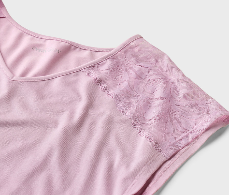 Nahaufnahme eines rosa Everyday-T-Shirts mit Spitzenärmeln auf einem weißen Hintergrund.