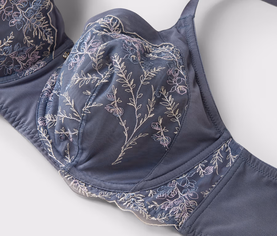 Detailaufnahme eines blauen BHs mit floraler Stickerei.