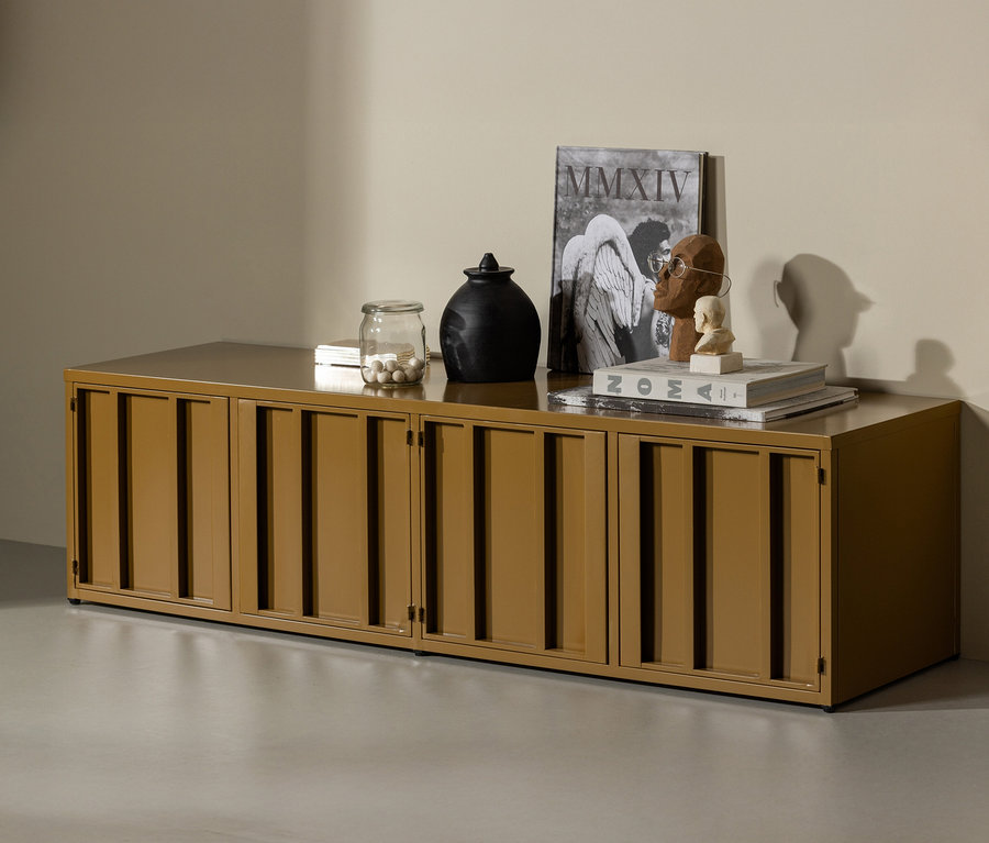 Honiggelber WOOOD Metall-TV-Schrank »Level« mit Deko-Objekten auf hellgrauem Boden.