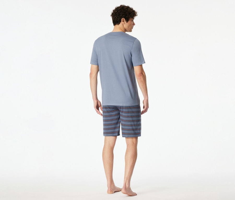 Rückansicht eines Mannes mit blauem T-Shirt und gestreiften Shorts vor einem weißen Hintergrund.