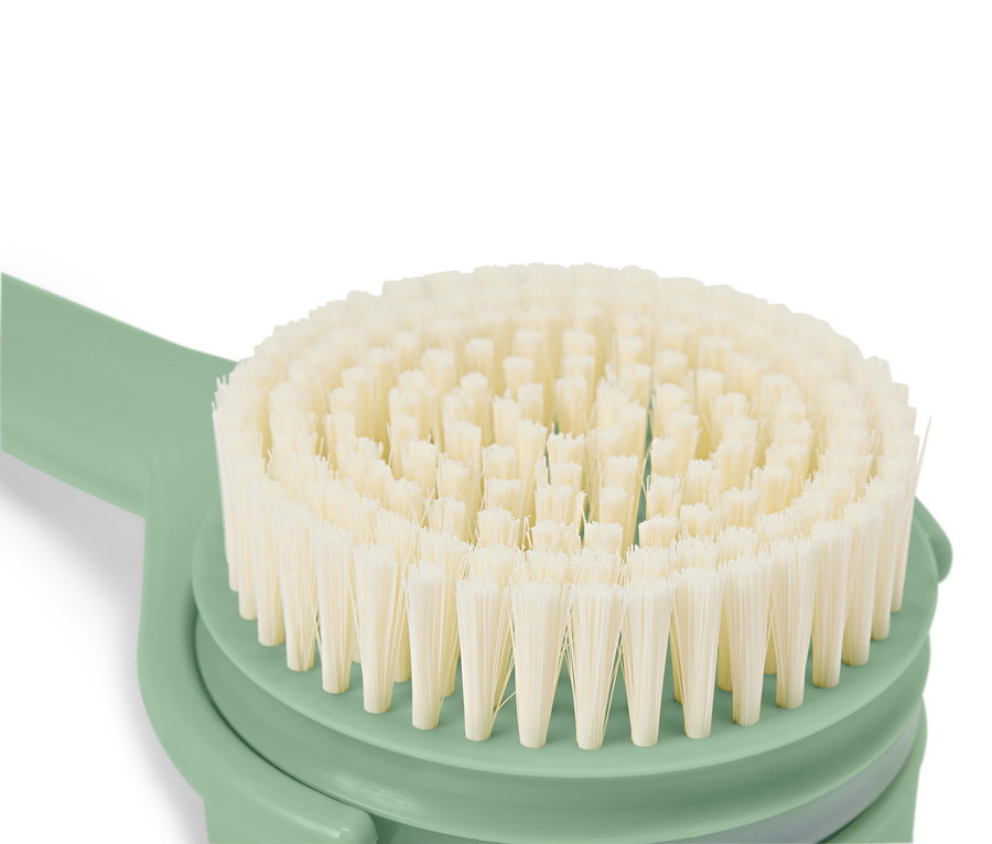 Nahaufnahme einer runden Bürste mit hellen Borsten und einem mintgrünen Griff.