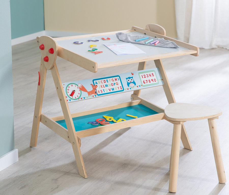 Ein hölzerner Kindermaltisch mit schräger grauer Platte, Magnetbuchstaben, Zeichnung und Kreiden. Darunter ein Lernbalken mit Fuchs, Alphabet und Zahlen sowie eine blaue Ablage mit weiteren Buchstaben. Daneben steht ein kleiner Holzhocker.
