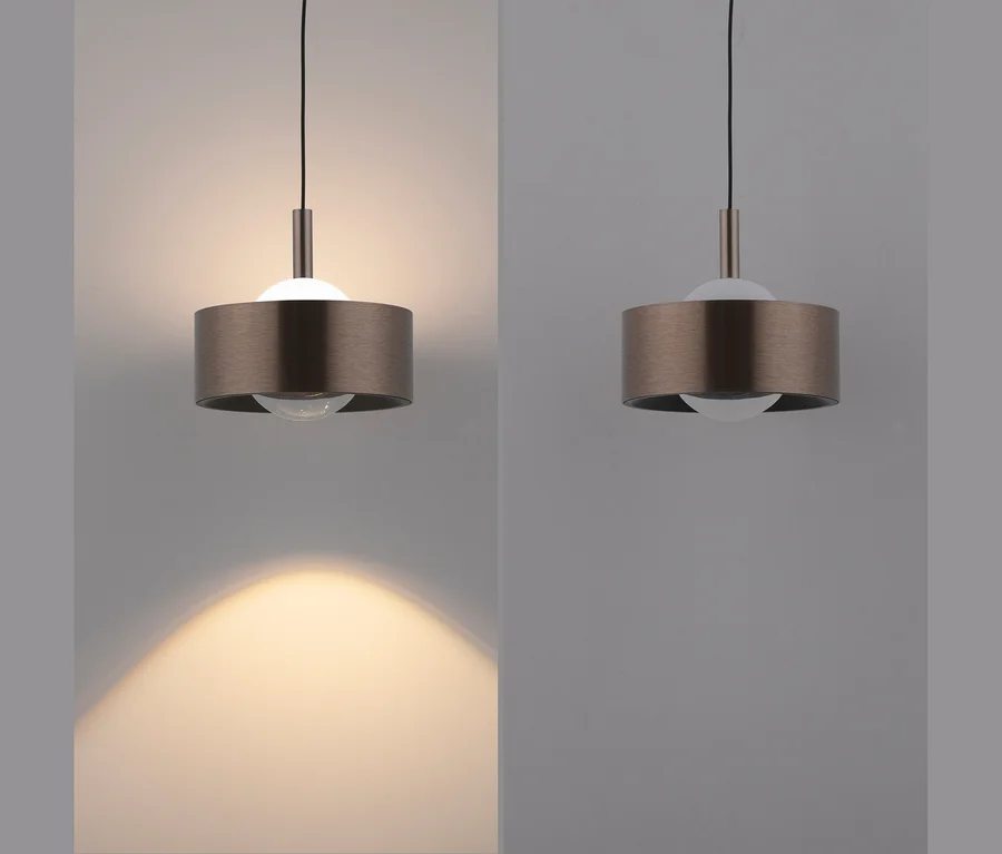 Zwei identische Bilder einer bronzefarbenen Pendelleuchte. Links ist die Leuchte eingeschaltet und wirft ein warmes Licht nach unten. Rechts ist die Leuchte ausgeschaltet.