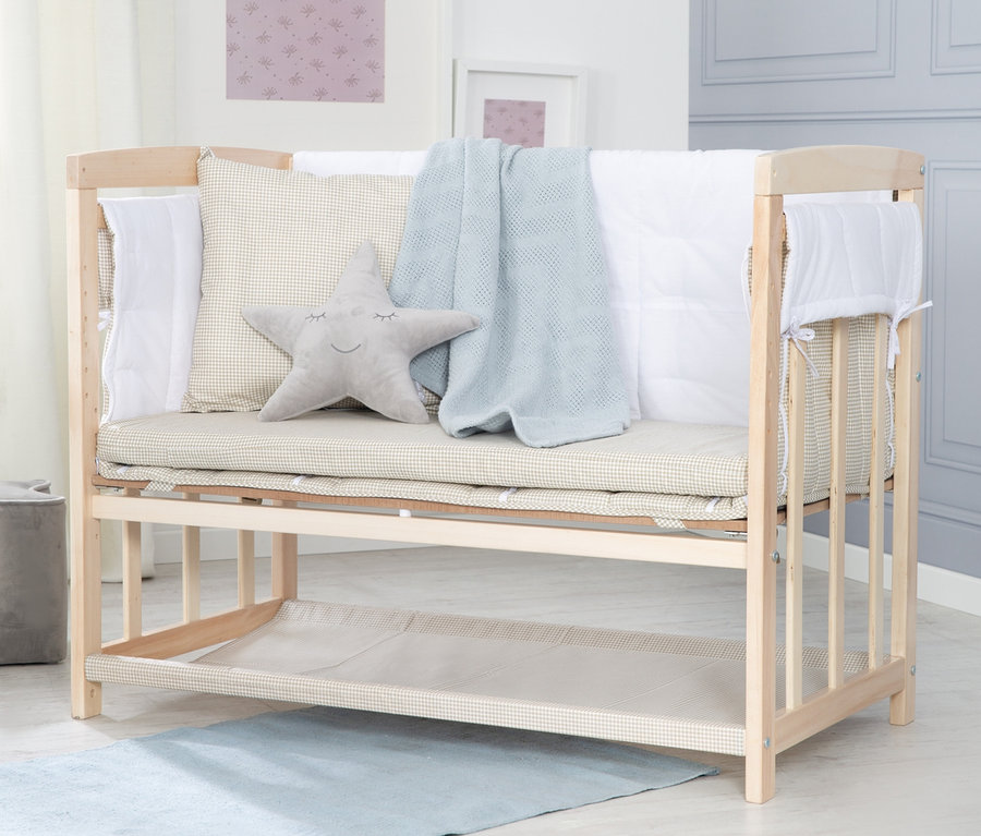 Gitterbett mit Sternkissen, Decke und Bettwäsche.