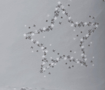 Ein Stern, der aus Schneeflocken und Sternen auf grauem Hintergrund besteht. Jersey-Bettwäsche dargestellt.