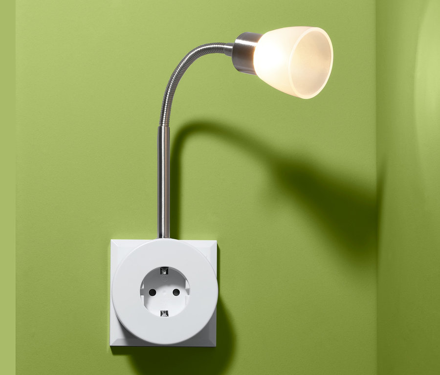 An einer grünen Wand ist eine LED-Schwenkleuchte angebracht.