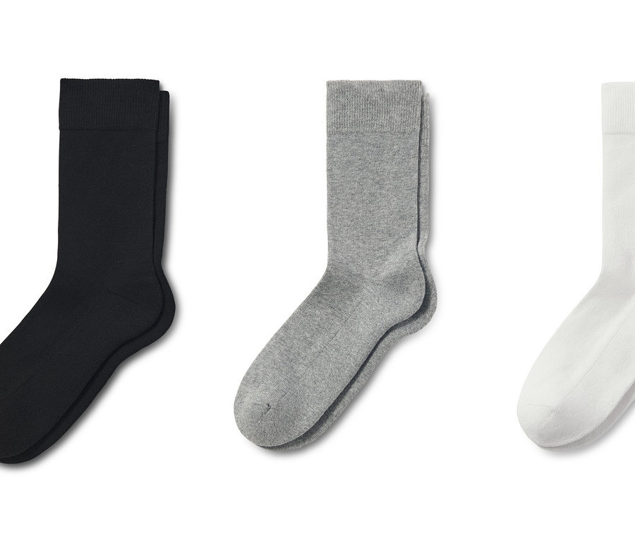 Drei Paar Socken: Schwarz, Grau und Weiß.