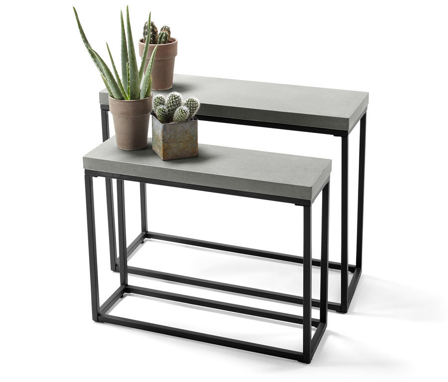 Zwei Konsolentische mit Beton-Tischplatten und schwarzen Metallgestellen, auf denen Pflanzen stehen.