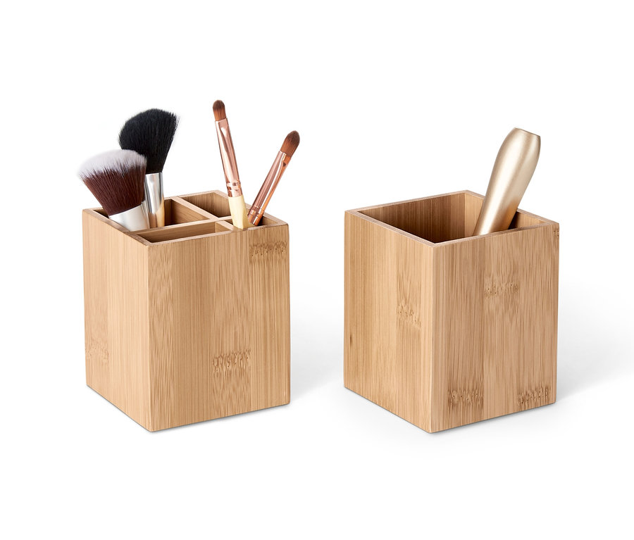 Zwei Organizer aus Bambus, einer mit Fächern und Make-up-Pinsel, der andere mit einer Flasche.