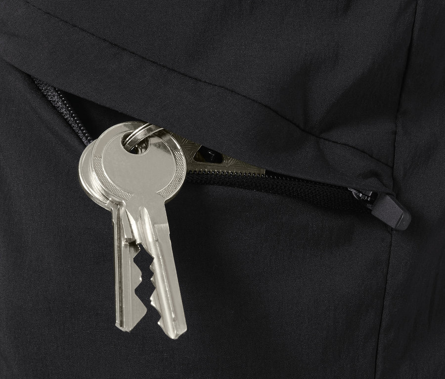 Schlüssel hängen aus einer geöffneten Tasche an Funktionswandershorts.
