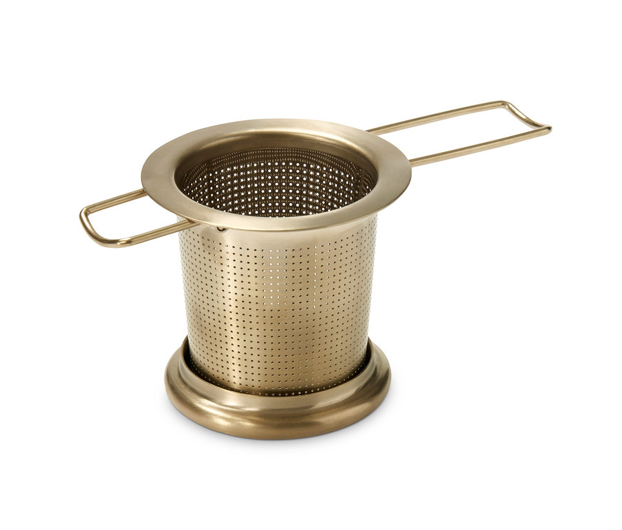 Nahaufnahme eines goldenen Teesiebs auf weißem Hintergrund.