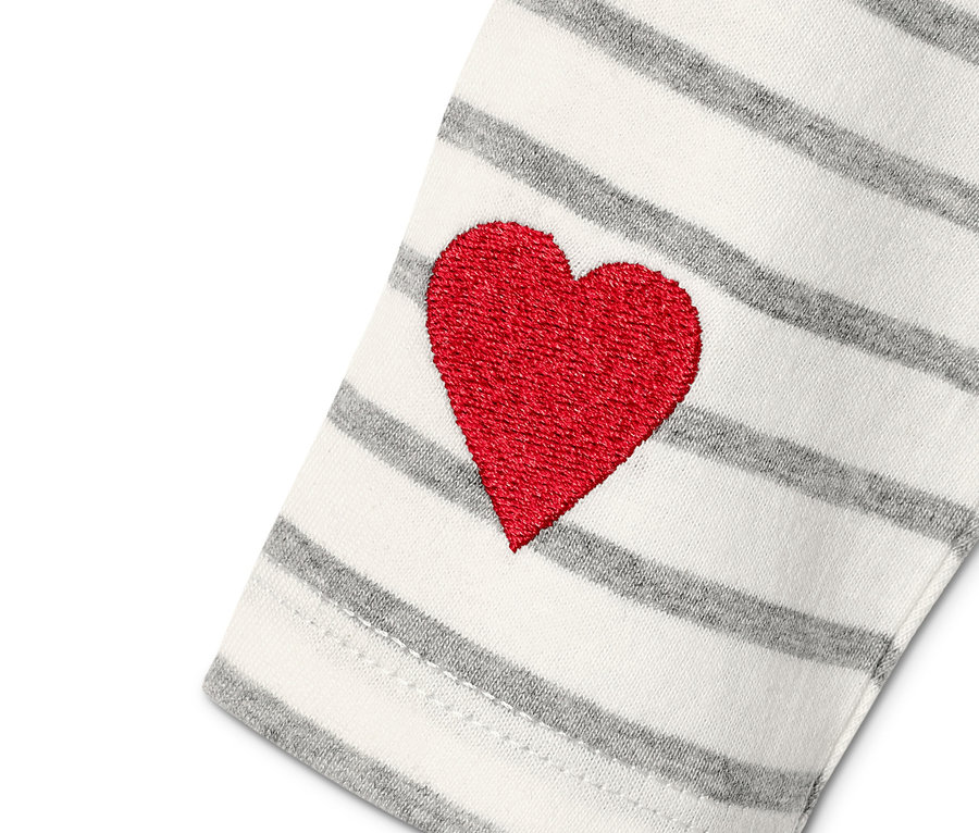 Detailansicht von einem Baby-Starter-Set aus Bio-Baumwolle mit rotem Herz auf grau-weiß gestreiftem Ärmel.