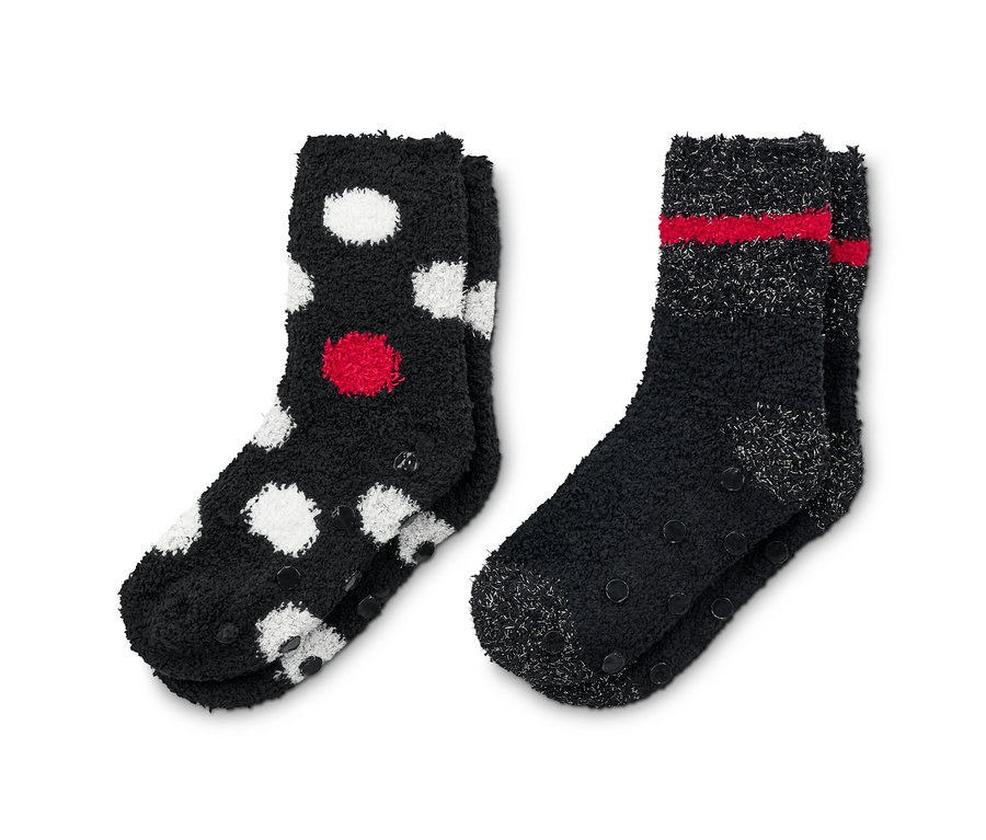 Zwei Paar Kuschelsocken: ein Paar schwarz mit roten und weißen Punkten, das andere schwarz mit roten Streifen.